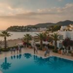 Turistlerle dolu bir tatil beldesi ve otel personeli.